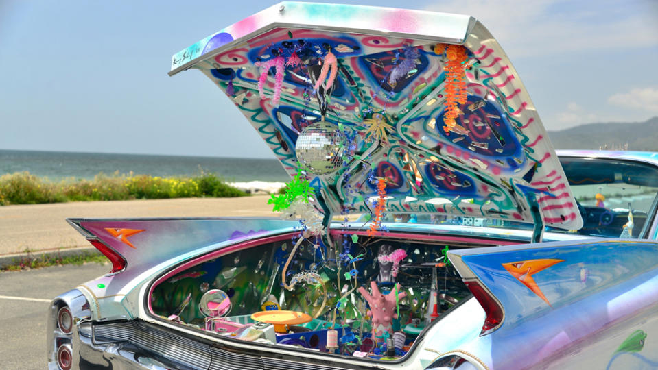 An LP turntable and disco ball are among the eclectic embellishments that festoon the trunk of artist Kenny Scharf’s reimagined 1960 Cadillac Coupe De Ville.