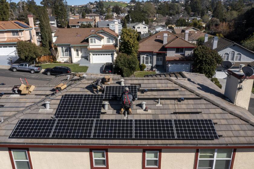 Save A Lot Solar contractors install LG Electronics solar panels on a home in Hayward, California, U.S., on Tuesday, Feb. 8, 2022. California regulators are delaying a vote on a controversial proposal to slash incentives for home solar systems as they consider revamping the measure. Photographer: David Paul Morris/Bloomberg via Getty Images