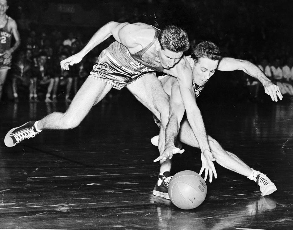 FILE - Kentucky forward Jim Line, left, and St. John's Dick McGuire chase a loose ball in the first half of an NCAA college basketball game at Madison Square Garden in New York, Dec. 24, 1947. Kentucky won the game 52-40. The first AP Top 25 men's college basketball poll was published on Jan. 17, 1949. The notion of subjectivity always has been essential to the Top 25. Voters understand there is no room for biases, and given that individual ballots are made public each week, they also know full-well that their opinions may come under intense scrutiny. (AP Photo/File)