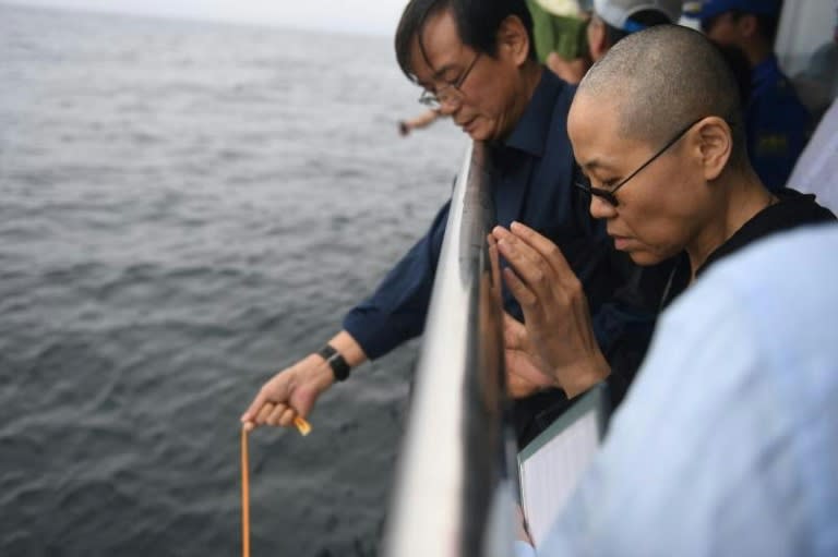 The late Nobel laureate Liu Xiaobo's wife Liu Xia praying as they bury Liu's ashes at sea off the coast of Dalian, Liaoning Province, on July 15, 2017