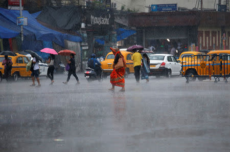 Commuters cross a road during heavy rains in Kolkata, India, May 3, 2019. REUTERS/Rupak De Chowdhuri