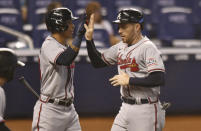 Atlanta Braves' Freddie Freeman, right, is congratulated by teammate Ehire Adrianza after scoring a run in the first inning of a baseball game against the Miami Marlins, Sunday, June 13, 2021, in Miami. (AP Photo/Jim Rassol)