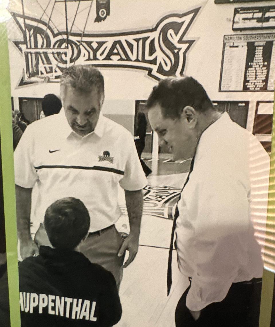 A photo hanging in former Hamilton Southeastern coach Chris Huppenthal's office of him and his older brother, Lake Central coach Joe Huppenthal, asking their nephew Brendan who he's rooting for in the Lake Central-HSE game.