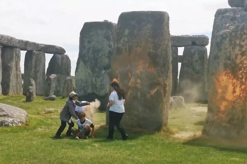 Just Stop Oil protesters spraying an orange substance on Stonehenge