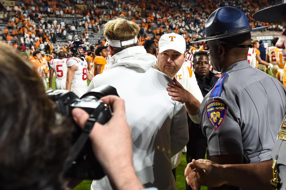 Tennessee coach Josh Heupel (facing camera) and Mississippi coach Lane Kiffin meet at midfield after their game at Neyland Stadium.