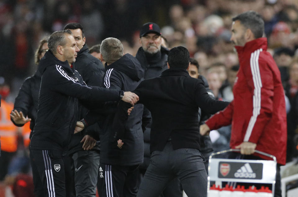 Liverpool manager Jurgen Klopp (with cap) clashes with Arsenal manager Mikel Arteta (black top). 