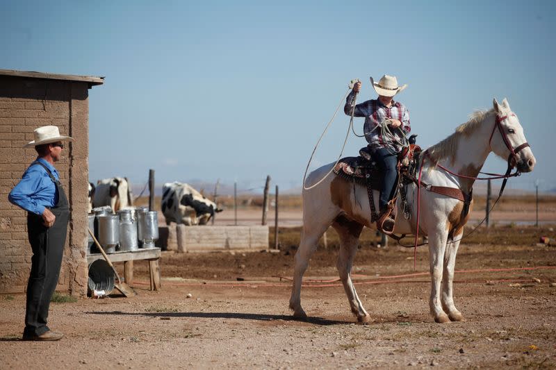 Un padre observa a su hijo mientras monta un caballo fuera de su casa en la comunidad menonita de Buenos Aires, Janos, Chihuahua, México