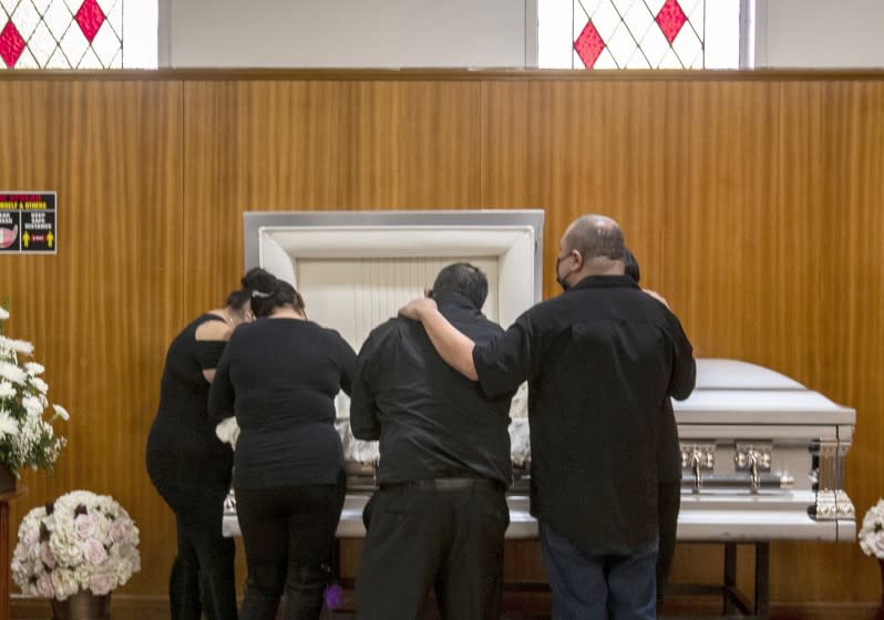 EAST LOS ANGELES, CA - DECEMBER 20: Family members gather to mourn Edith Fernandez alongside her casket at the Continental Funeral Home on Sunday, Dec. 20, 2020 in East Los Angeles, CA. The 47-year-old died Dec. 8, 2020 from complications of Covid-19. (Brian van der Brug / Los Angeles Times)