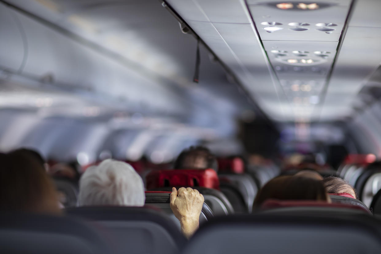 Fear of flying airplanes. Hand holding airplane seat.