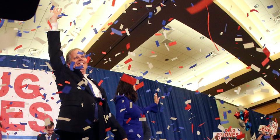 Confetti falls as Democrat Doug Jones and his wife Louise wave to supporters Tuesday, Dec. 12, 2017, in Birmingham, Ala.