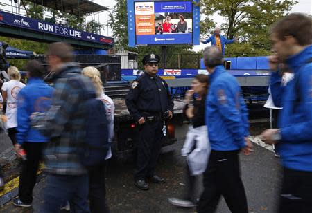 A New York City Police (NYPD) officer stands guard near the finish line of the New York City Marathon in New York's Central park November 1, 2013. REUTERS/Mike Segar