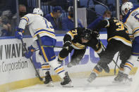 Boston Bruins left wing Taylor Hall (71) falls to the ice after checking Buffalo Sabres defenseman Mark Pysyk (13) during the second period of an NHL hockey game Friday, Oct. 22, 2021, in Buffalo, N.Y. (AP Photo/Joshua Bessex)