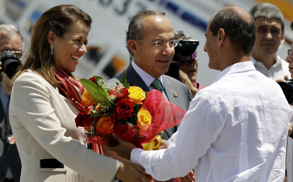 Mexico's President Felipe Calderon, center, and his wife Margarita Zavala, are welcomed by Cuba's Vice-Foreign Minister Rogelio Sierra, right, upon their arrival at the Jose Marti airport in Havana, Cuba, Wednesday, April 11, 2012. Calderon is on a two-day official visit to Cuba. (AP Photo/Javier Galeano)