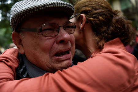 A man is comforted as he gets excited outside a polling station after casting his vote for the banned separatist referendum in Barcelona, Spain, October 1, 2017. REUTERS/Eloy Alonso