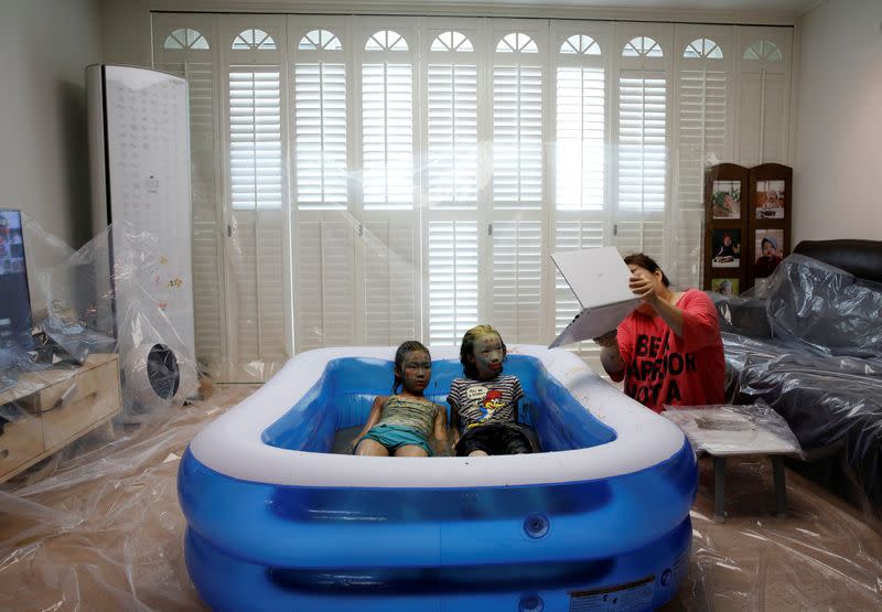 Children play in a mud pool during the Online Boryeong Mud Festival at their home during a live streaming event, in Gwangju