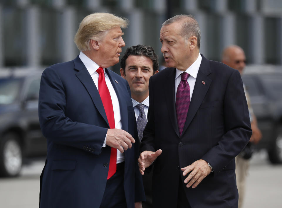 FILE - In this Wednesday, July 11, 2018, file photo, President Donald Trump, left, talks with Turkey's President Recep Tayyip Erdogan, as they arrive together for a family photo at a summit of heads of state and government at NATO headquarters in Brussels. The White House says Turkey will soon invade Northern Syria, casting uncertainty on the fate of the Kurdish fighters allied with the U.S. against in a campaign against the Islamic State group. (AP Photo/Pablo Martinez Monsivais, File)