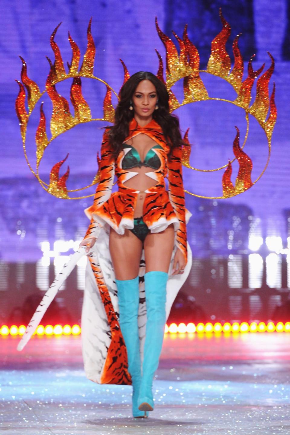 <p>Joan Smalls modelled a very wild outfit in 2012, complete with a tiger print cape and fire rings. [Photo: Getty] </p>