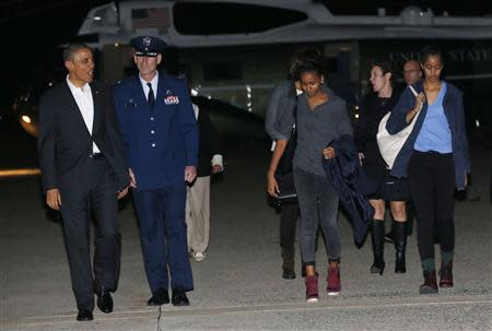 U.S. President Barack Obama and his family depart Joint Base Andrews in Washington, to Hawaii for vacation, December 20, 2013. With Obama are daughters Sasha (C) and Malia (R). REUTERS/Kevin Lamarque