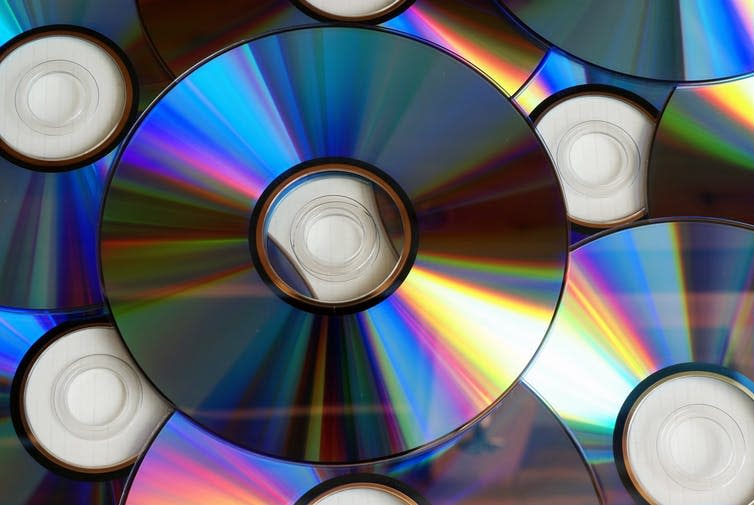 Pile of compact discs with light shining on them
