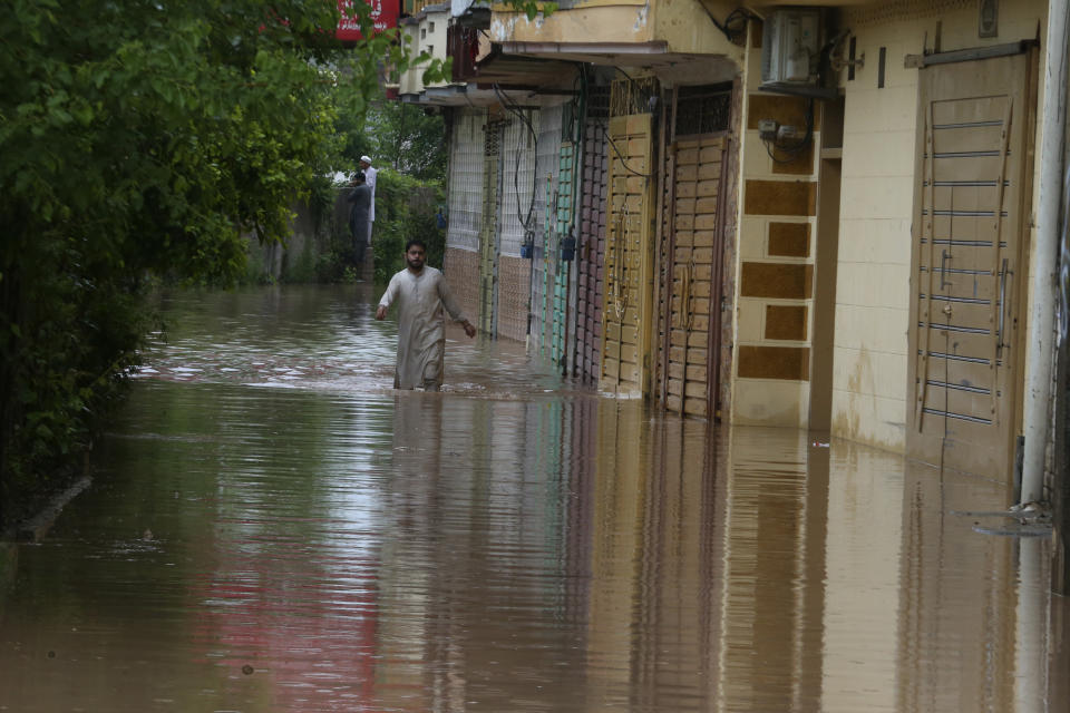 A Pakistani wades through a flooded street caused by heavy rain in Peshawar, Pakistan, Monday, April 15, 2024. Lightening and heavy rains killed dozens of people, mostly farmers, across Pakistan in the past three days, officials said Monday, as authorities declared a state of emergency in the country's southwest following an overnight rainfall to avoid any further casualties and damages. (AP Photo/Muhammad Sajjad)