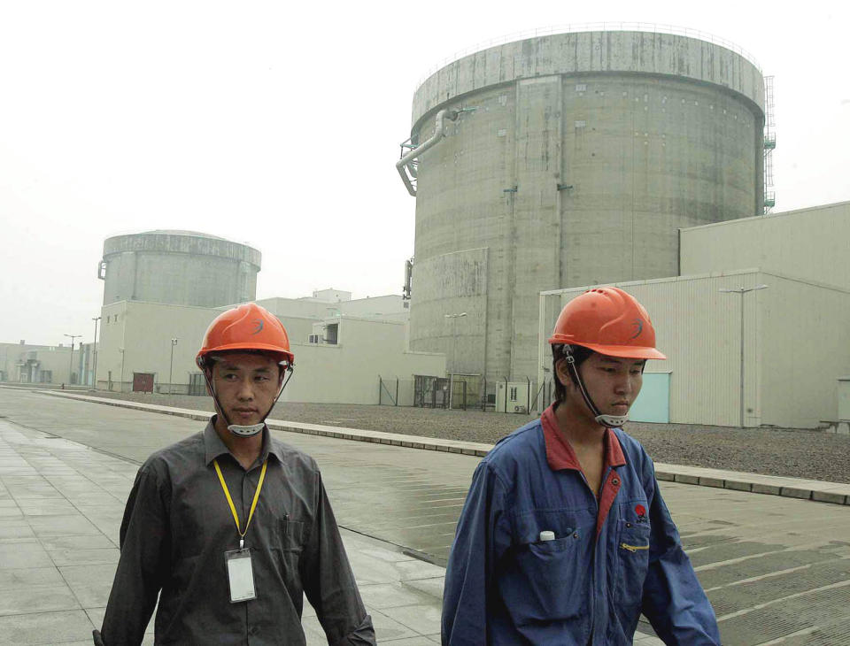 FILE - In this June 10, 2005 file photo, workers walk past a part of Qinshan No. 2 Nuclear Power Plant, China's first self-designed and self-built national commercial nuclear power plant in Qinshan, about 125 kilometers (about 90 miles) southwest of Shanghai, China. China is ready to approve new nuclear power plants as part of ambitious plans to reduce reliance on oil and coal, ending a moratorium it imposed because of Japan's Fukushima disaster in 2011. The Cabinet on Wednesday, Oct. 24, 2012, passed plans on nuclear power safety and development that said construction of nuclear power plants would resume "steadily." (AP Photo/Eugene Hoshiko, File)