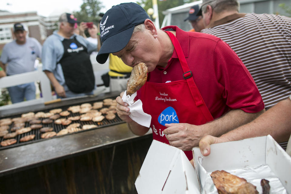 <p>Sen. Lindsey Graham (R-S.C.) takes a bite out of a pork chop at the Iowa Pork Producers Association stand.</p>