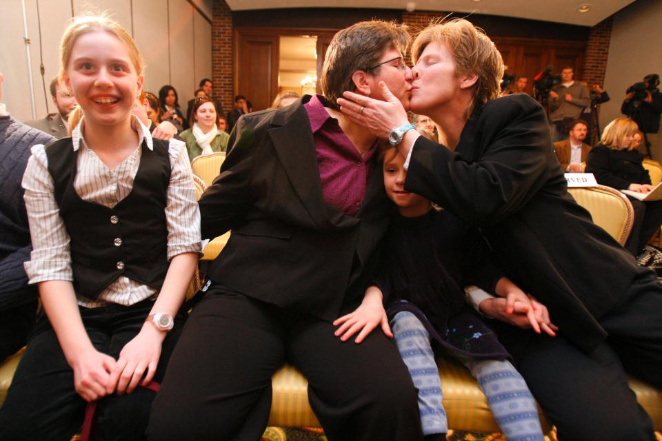 Dawn BarbouRoske, second from left, of Iowa City, kisses her partner, Jen BarbouRoske, after learning of the Iowa Supreme Court ruling in favor of legalizing gay marriage in Iowa on Friday, April 3, 2009 in Des Moines.  Between them is their daughter Bre, 6. Their other daughter, McKinley, 11, reacts to the ruling a left. (Christopher Gannon/The Des Moines Register)