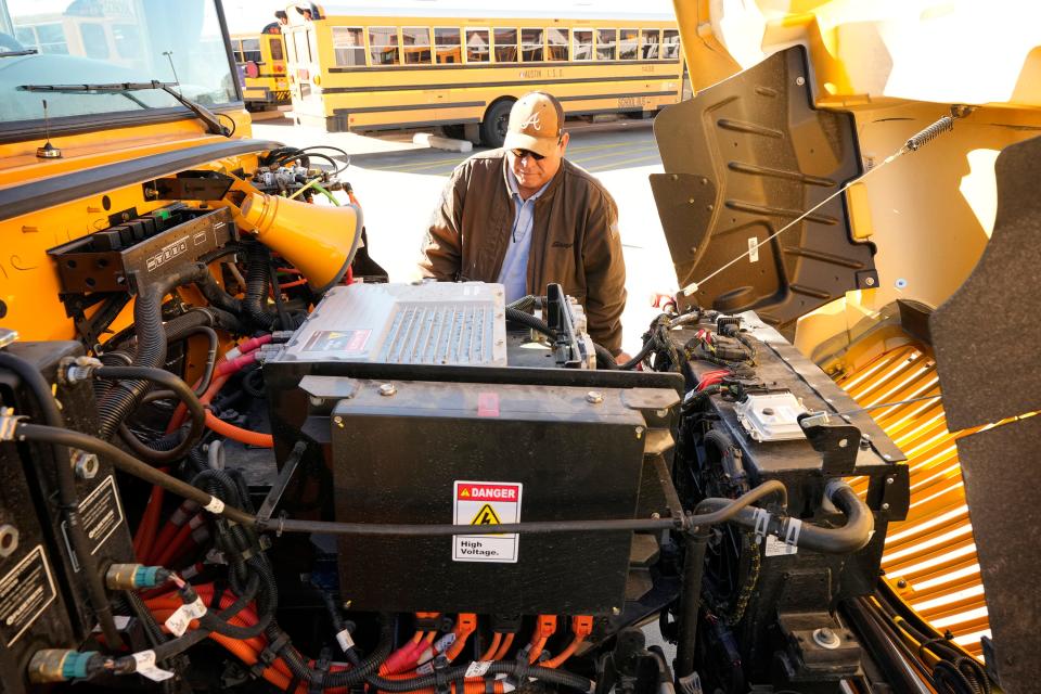 Assistant shop foreman Roland Garcia looks at the engine of an electric school bus at the Austin Independent School District Southeast Bus Terminal on Monday January 29, 2024.