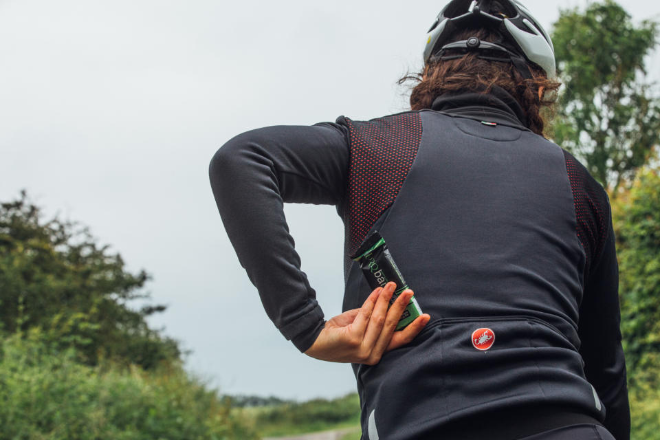 Female cyclist grabbing an energy bar from her jersey pocket