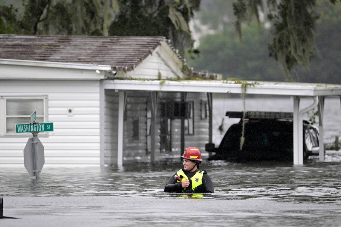 A first responder with Orange County Fire Rescue makes her way through floodwaters looking for residents of a neighborhood needing help in the aftermath of Hurricane Ian, Thursday, Sept. 29, 2022, in Orlando, Fla.
