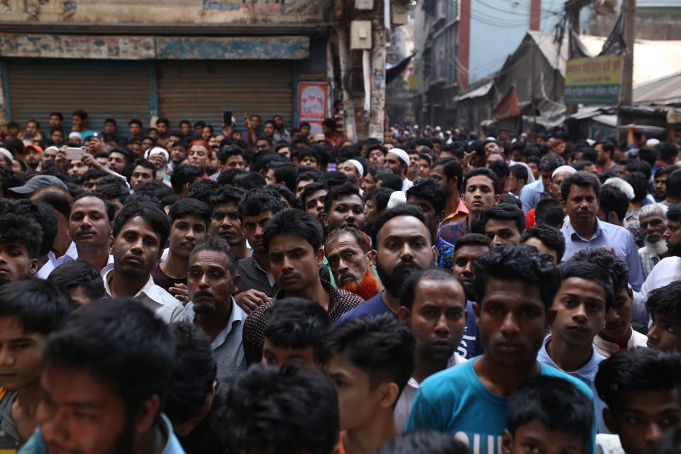 A crowd gathers at the site of a fire accident in Dhaka, Bangladesh, Thursday, Feb. 21, 2019. A devastating fire raced through at least five buildings in an old part of Bangladesh's capital and killed scores of people. (AP Photo/Rehman Asad)