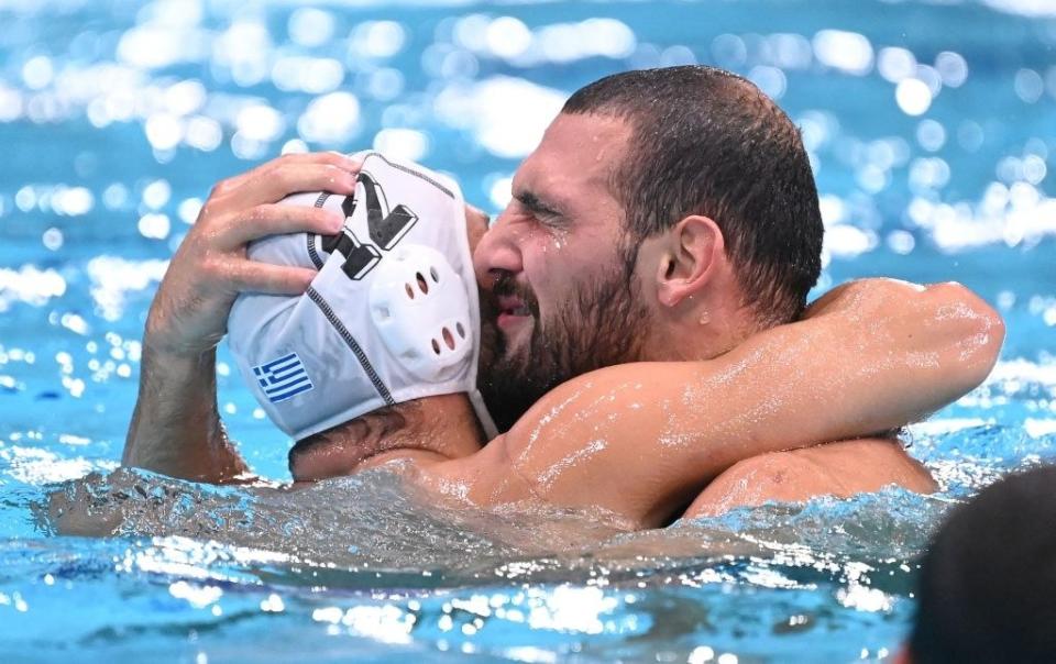 The Greek athletes hugging each other in the water