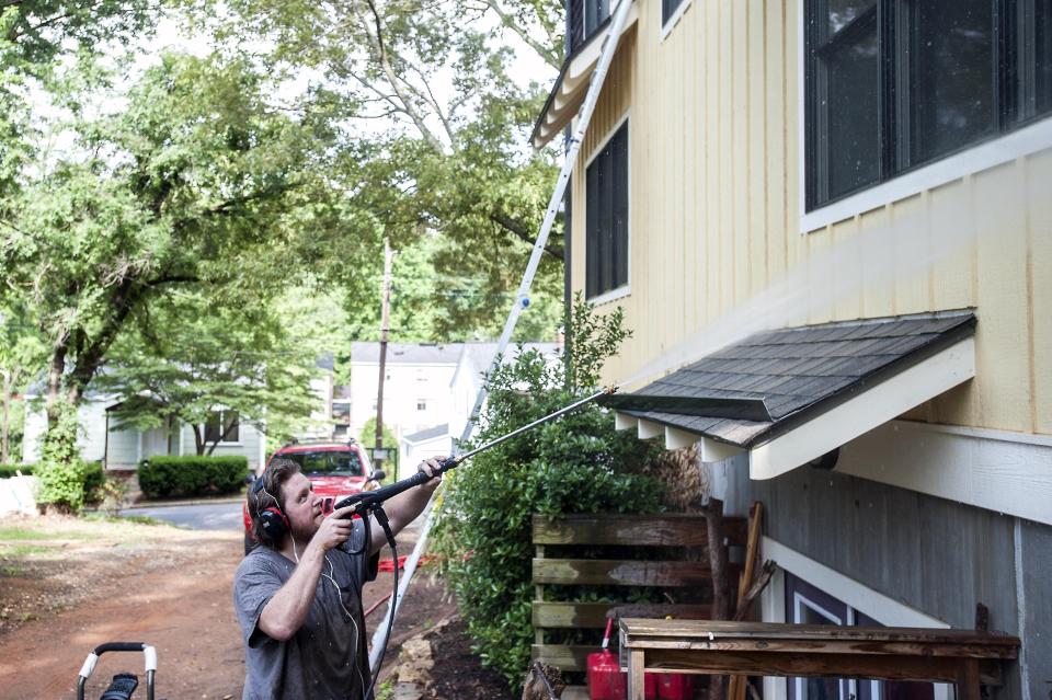 Shawn Johnson pressure washes a house in West Asheville. Johnson become almost an urban legend among the 15,000 members of the West Asheville Exchange Facebook group. Down on his luck, Johnson found a supportive community and offers for handyman work as Shawn of All Trades.