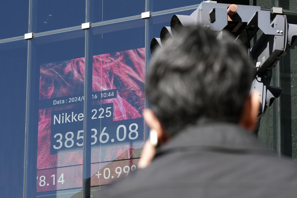 A person stands near an electronic stock board showing Japan's Nikkei 225 index at a securities firm Friday, Feb. 16, 2024, in Tokyo. Shares advanced in Asia on Friday, with Tokyo's benchmark Nikkei 225 index trading near a record high, 34 years after it peaked and then plunged with the collapse of Japan's financial bubble. (AP Photo/Eugene Hoshiko)