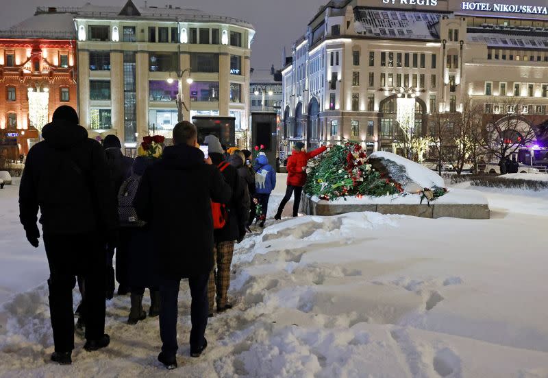 People gather at the monument to the victims of political repressions following the death of Alexei Navalny in Moscow