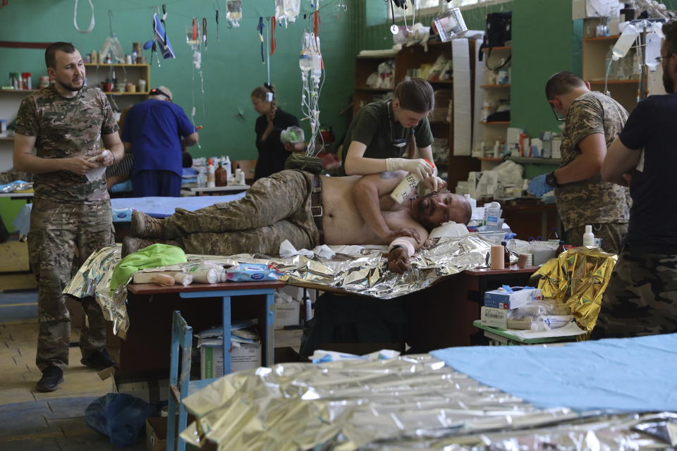 Medics help an injured Ukrainian serviceman in a frontline medical stabilization point in Zaporizhzhia region, Ukraine, Wednesday, July 26, 2023. (AP Photo/Kateryna Klochko)