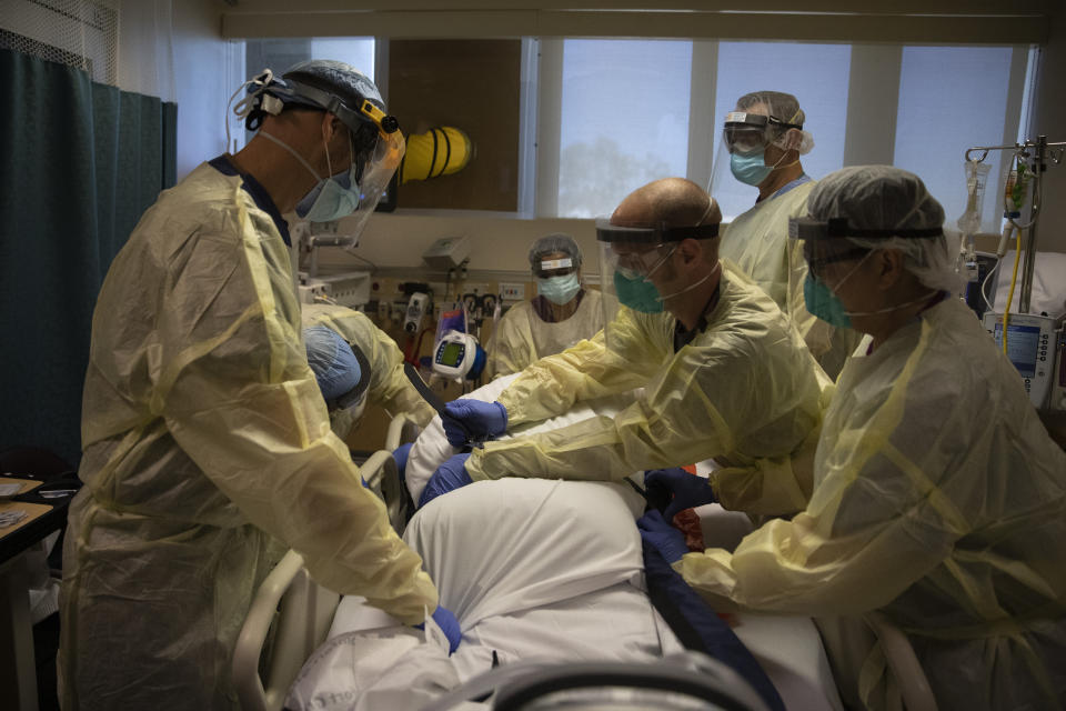 Healthcare professionals including Dr. Michael Katz, left, turn a COVID-19 patient over onto his back at St. Jude Medical Center in Fullerton, Calif., Friday, July 10, 2020. The pandemic rages on and cases climb throughout California, once again one of the nation's hot spots. The nurses forge ahead. They care for their patients during 12-hour shifts, taking temperatures and holding hands through gloves and wondering when, if, it will all end. (AP Photo/Jae C. Hong)