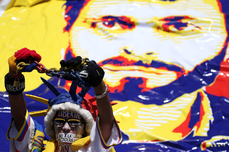 <p>An opposition supporter wearing a costume poses in front of an image depicting jailed Venezuelan opposition leader Leopoldo Lopez, during a rally to mark the third anniversary of his arrest, in Caracas, Venezuela, Feb. 18, 2017. (Carlos Garcia Rawlins/Reuters) </p>