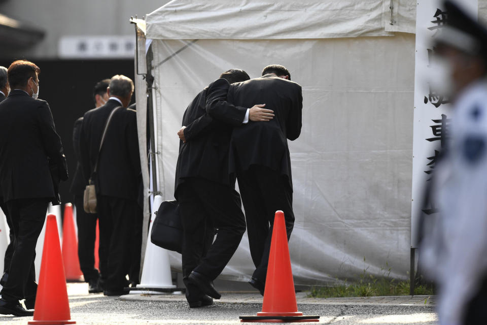 Attendees wait together at Zojoji temple before his funeral wake for former Japanese Prime Minister Shinzo Abe, Monday, July 11, 2022, in Tokyo. Abe was assassinated Friday while campaigning in Nara, western Japan.(Kyodo News via AP)
