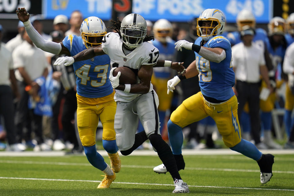 Las Vegas Raiders wide receiver Davante Adams (17) runs in front of Los Angeles Chargers cornerback Michael Davis (43) and linebacker Drue Tranquill during the first half of an NFL football game in Inglewood, Calif., Sunday, Sept. 11, 2022. (AP Photo/Gregory Bull)