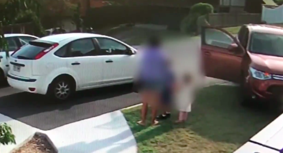 The mother and two children watch as the man makes off with her car. Source: Queensland Police