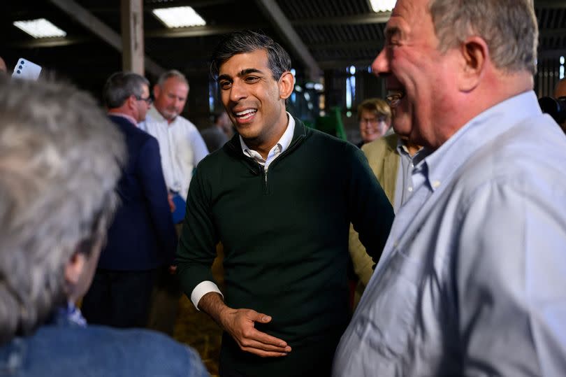 Rishi Sunak pictured speaking to people whilst campaigning