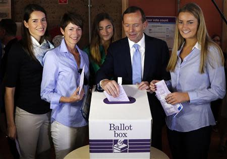 Tony Abbott (2nd R), who leads the conservative opposition, casts his vote as his wife Margaret and daughters Louise, Frances and Bridget (L-R) look on at the Freshwater Beach Surf Lifesaving Club in Sydney, on election day September 7, 2013. REUTERS/David Gray