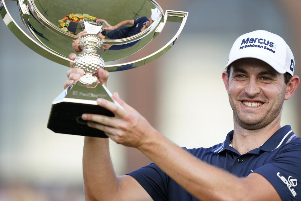 Patrick Cantlay holds up the trophy after winning the Tour Championship golf tournament and the FedEx Cup at East Lake Golf Club, Sunday, Sept. 5, 2021, in Atlanta. (AP Photo/Brynn Anderson)