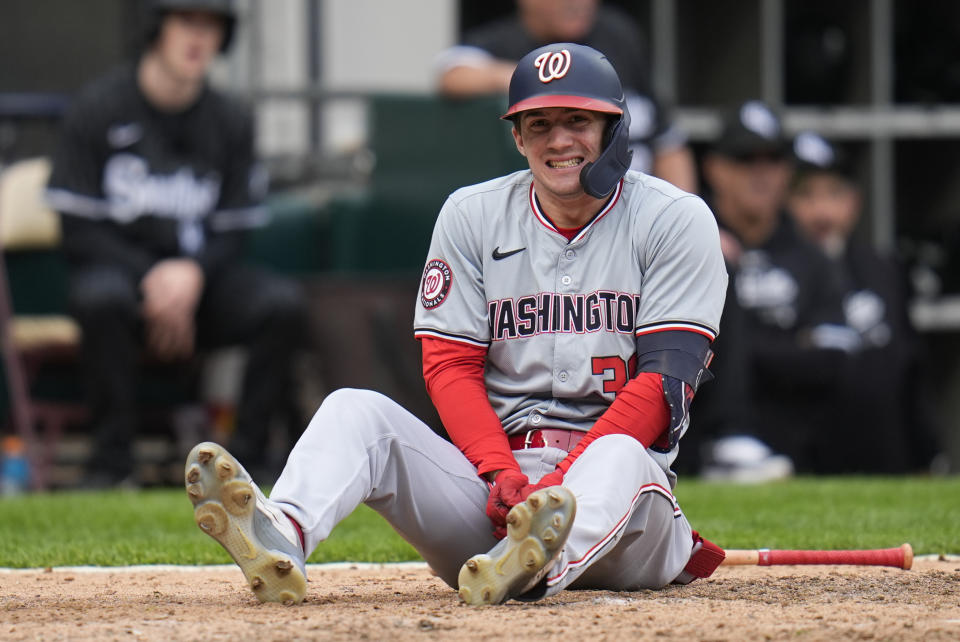 Washington Nationals' Jacob Young sits on the ground after hitting his hand while bunting during the seventh inning in the first baseball game of a doubleheader against the Chicago White Sox, Tuesday, May 14, 2024, in Chicago. (AP Photo/Erin Hooley)