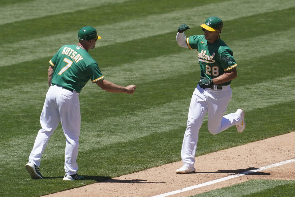 Oakland Athletics' Matt Olson, right, is congratulated by third base coach Mark Kotsay (7) after hitting a home run against the Kansas City Royals during the third inning of a baseball game in Oakland, Calif., Sunday, June 13, 2021. (AP Photo/Jeff Chiu)