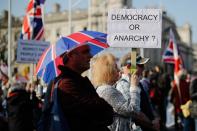 <p>A woman holds up a placard in the middle of a packed crowd (GETTY) </p>