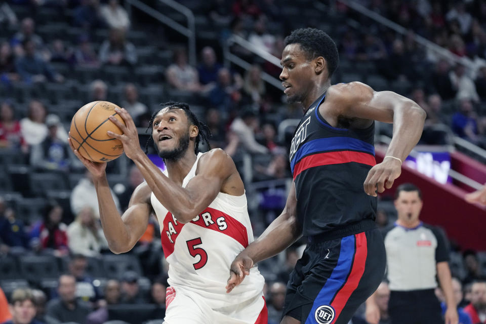 Toronto Raptors guard Immanuel Quickley (5) attempts a layup as Detroit Pistons center Jalen Duren defends during the first half of an NBA basketball game, Wednesday, March 13, 2024, in Detroit. (AP Photo/Carlos Osorio)