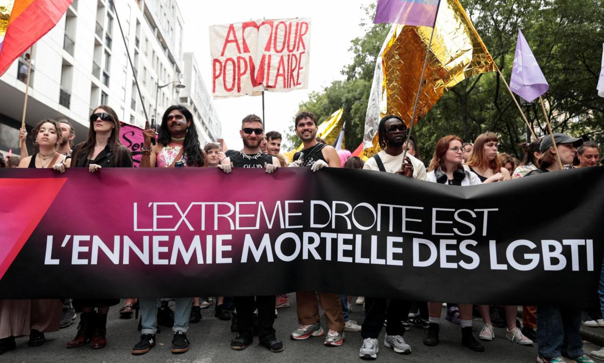 <span>At the Paris Pride march on the eve of French elections, attenders hold a banner that reads: ‘The far right is the mortal enemy of the LGBTI’.</span><span>Photograph: Abdul Saboor/Reuters</span>