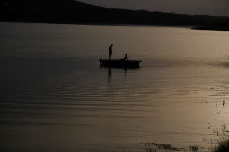 Two youths relax at the Alqueva reservoir, the largest artificial lake in the EU, near Alqueva, Portugal, August 2, 2018. REUTERS/Rafael Marchante